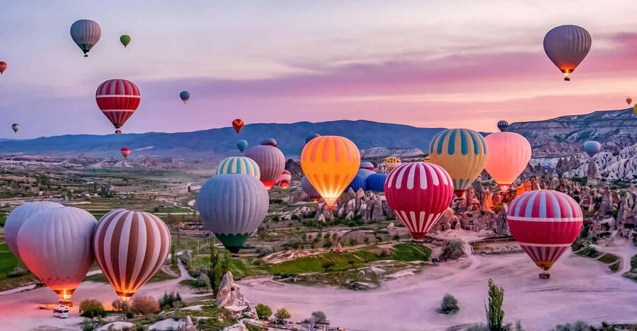 Balloons lifting over the rock chimneys at G&ouml;reme, Cappadocia