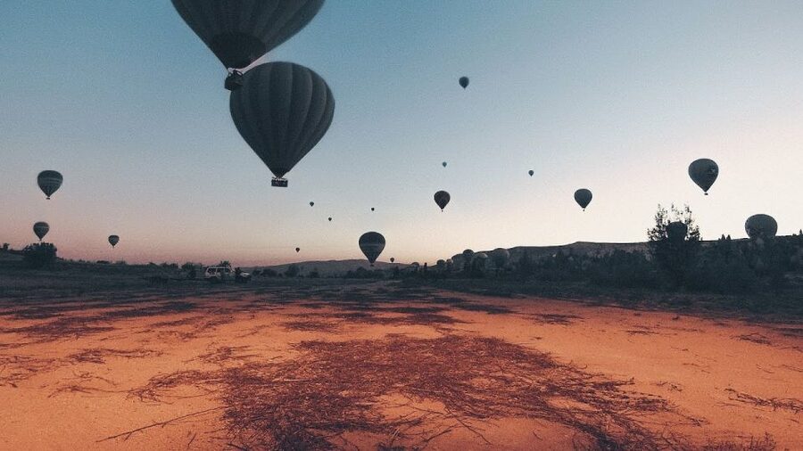 Hot air balloons in Goreme red valley - Kızılçukur and the changing morning color